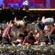 People scramble for shelter at the Route 91 Harvest country music festival after apparent gun fire was heard on October 1, 2017 in Las Vegas, Nevada. (Photo by David Becker/Getty Images)